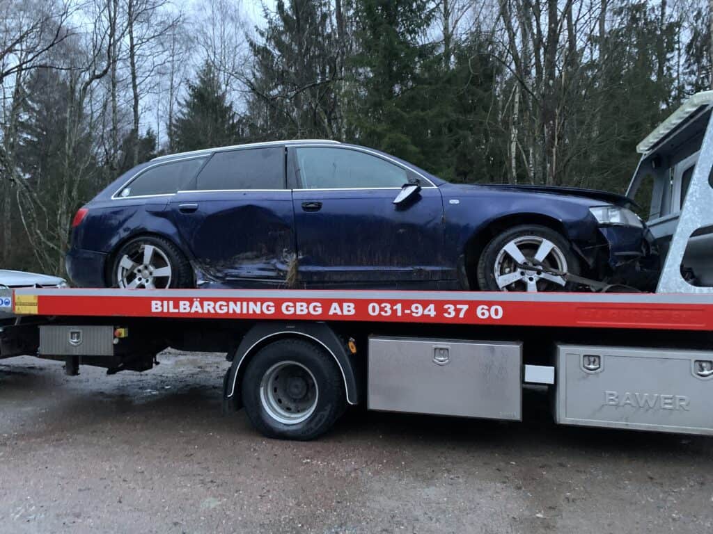 Skrotbil hämtas på Tjörn med bärgningsbil för transport till bilskrot och återvinning av delar och material.