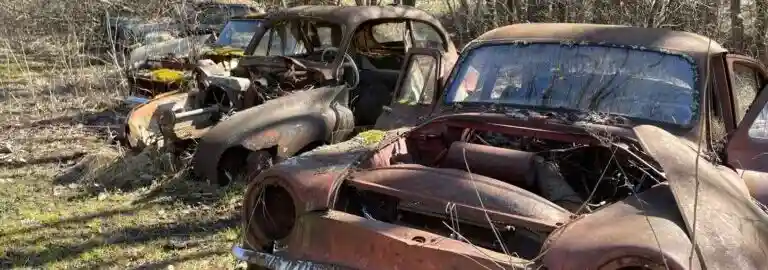 Defekt bil på bilskrot där fordonet analyseras inför demontering och återvinning av reservdelar och metall.